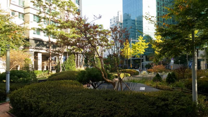 로비 중앙에는 주민 휴게시설이 넓게 자리하고 있으며 주변으로 조형물과 조경이 어우러져 있습니다