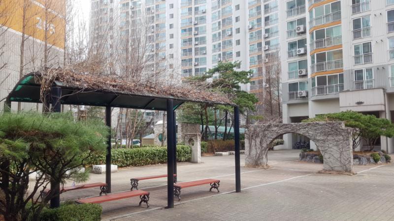 단지 중앙에는 주민 휴게시설이 넓게 자리하고 있으며 주변으로 조형물과 조경이 어우러져 있습니다