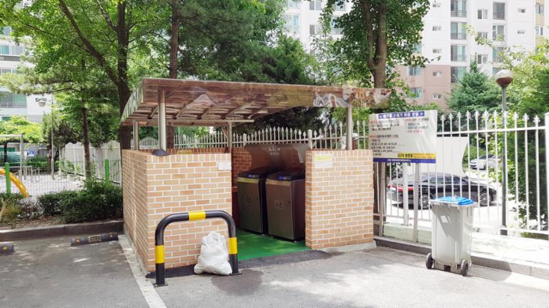 벽돌담과 지붕이 달린 분리수거장이에요