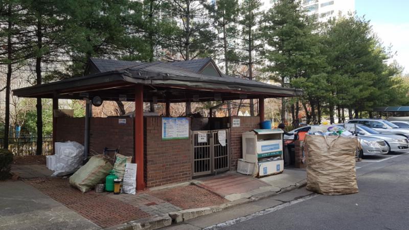 벽돌담과 지붕이 달린 분리수거장이에요