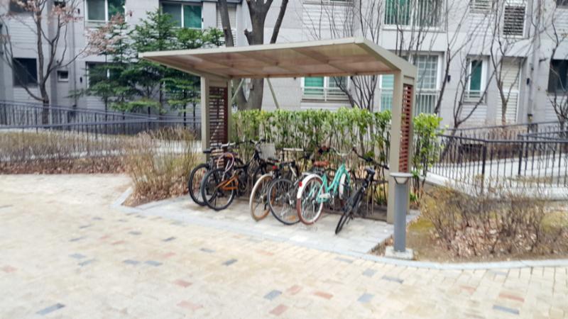 자전거를 이용하는 입주민들의 편의를 위한 설치된 단지 내 공용 자전거 보관소에요