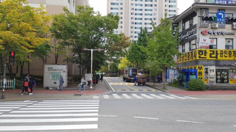 도로를 중심으로 정문이 우측에 위치해 있으며, 주변에는 상가들이 밀집해 있어요