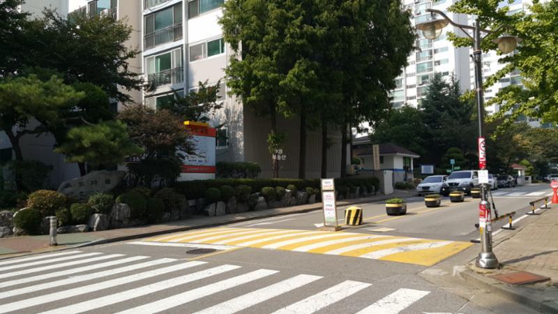보행자들의 안전을 고려하여 횡단보도가 있는 단지 내 정문이에요